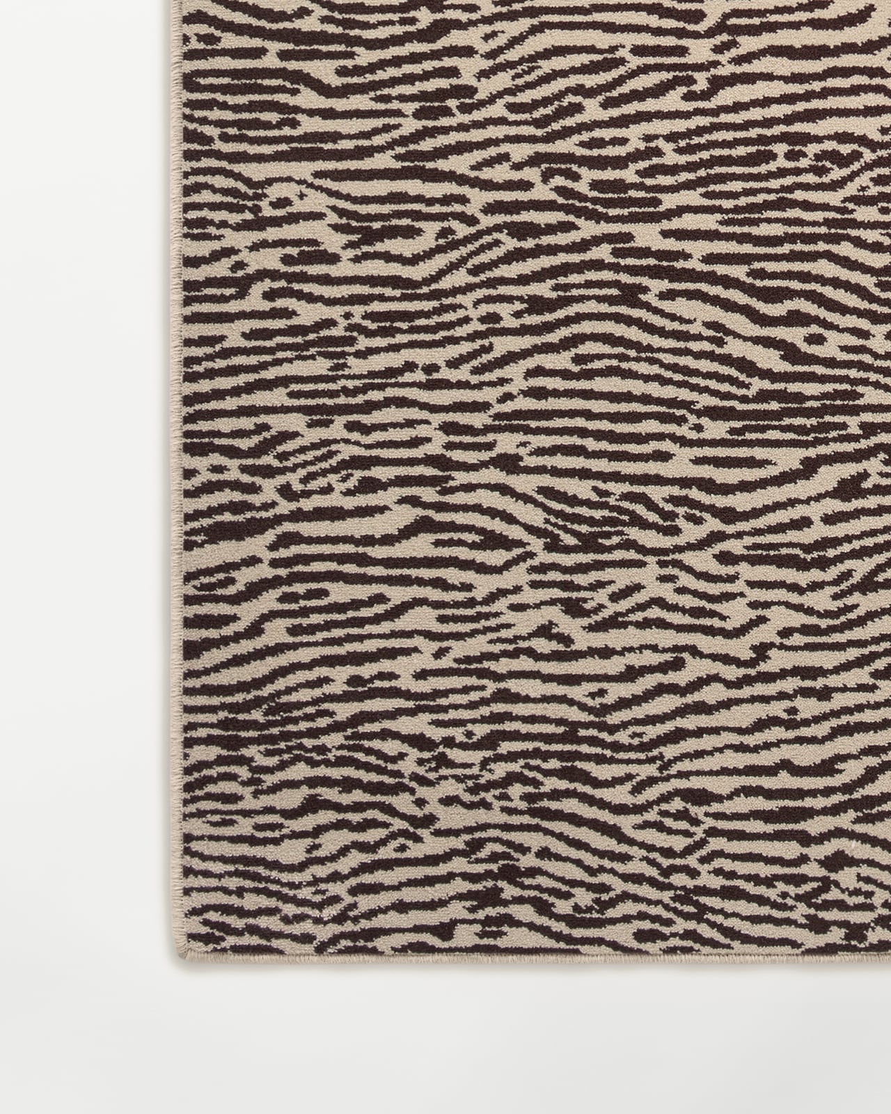 Close-up of the Animal wall-to-wall carpet in Beige/Walnut, showing the dense cut pile and organic animal motif.
