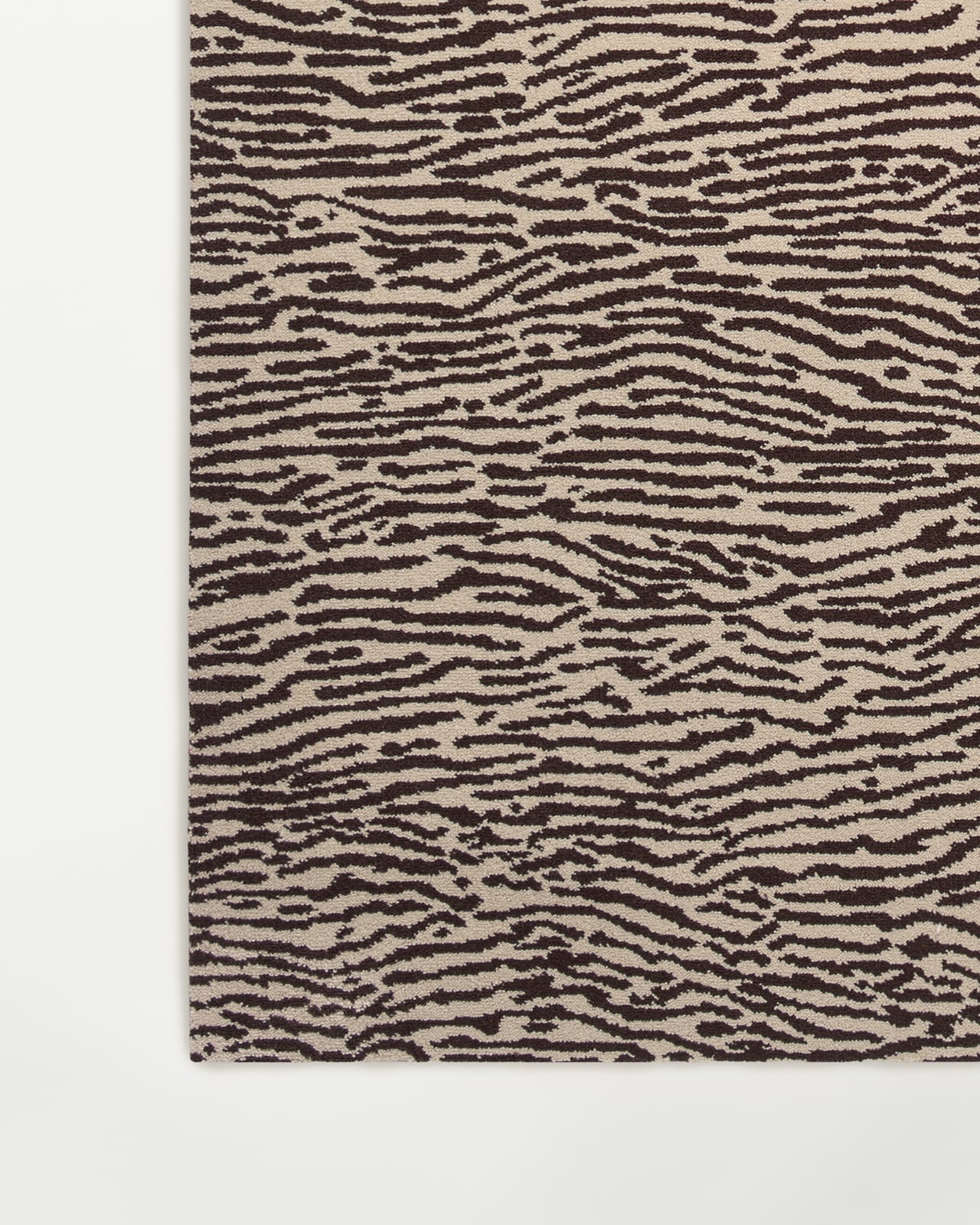 Close-up of the Animal wall-to-wall carpet in Beige/Walnut, showing the dense cut pile and organic animal motif.