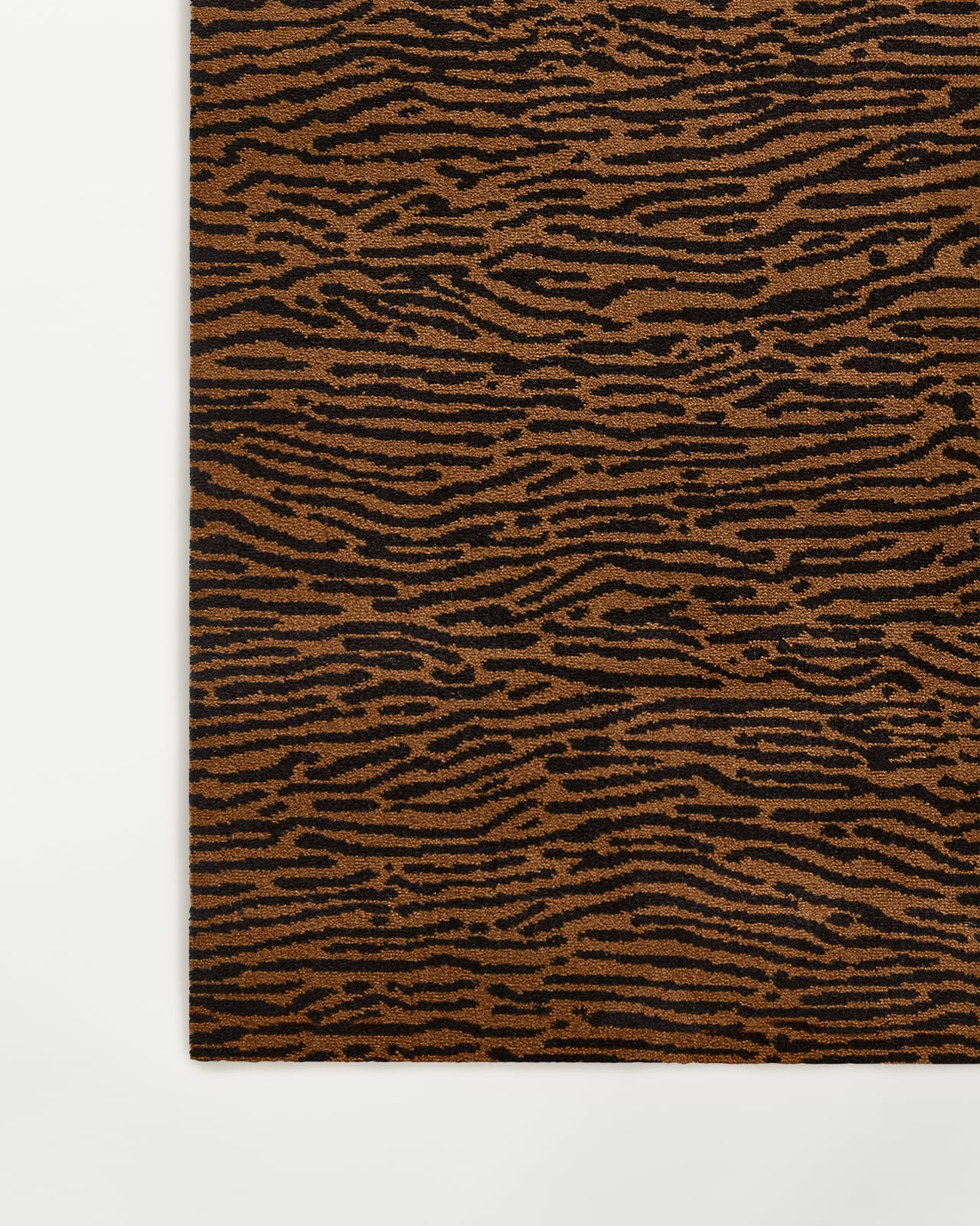 Close-up of the Animal wall-to-wall carpet in Pecan/Black, showing the dense cut pile with its organic animal-inspired motif.