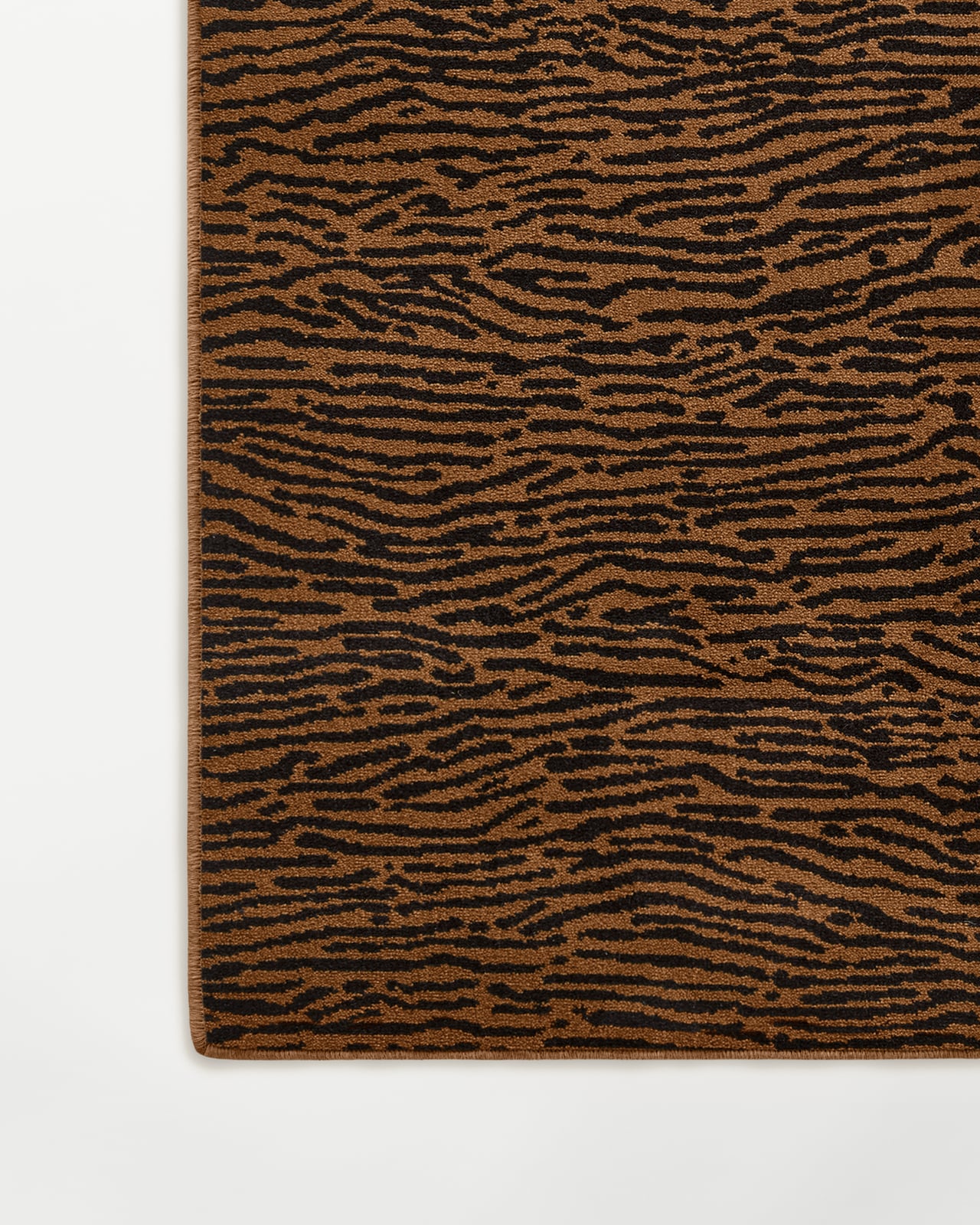 Close-up of the Animal wall-to-wall carpet in Pecan/Black, showing the dense cut pile and striped animal motif.