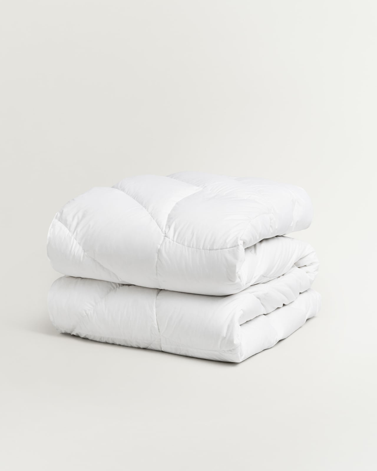 Down and Feather Duvet – Medium in White, a white cotton duvet with a stitched grid pattern, folded neatly.