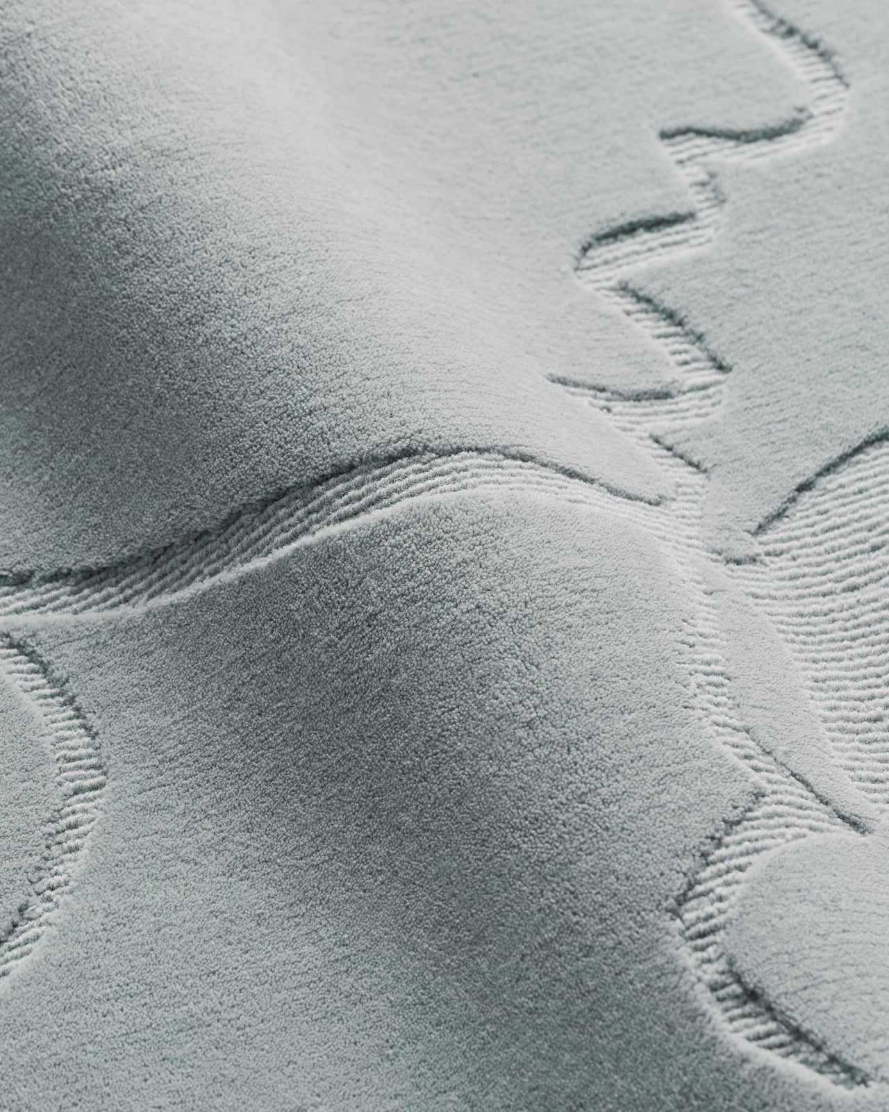 Dancing Flower in Dusty Blue - a plush wool rug with a subtle organic floral pattern.