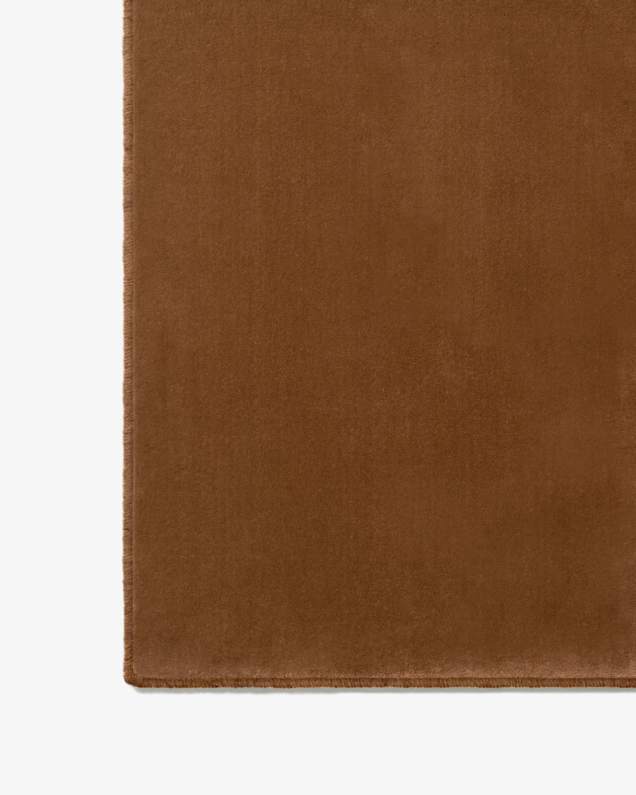 Close-up of Grand - Pecan in Pecan, showing its smooth cut pile surface and hand-stitched edge finishing.
