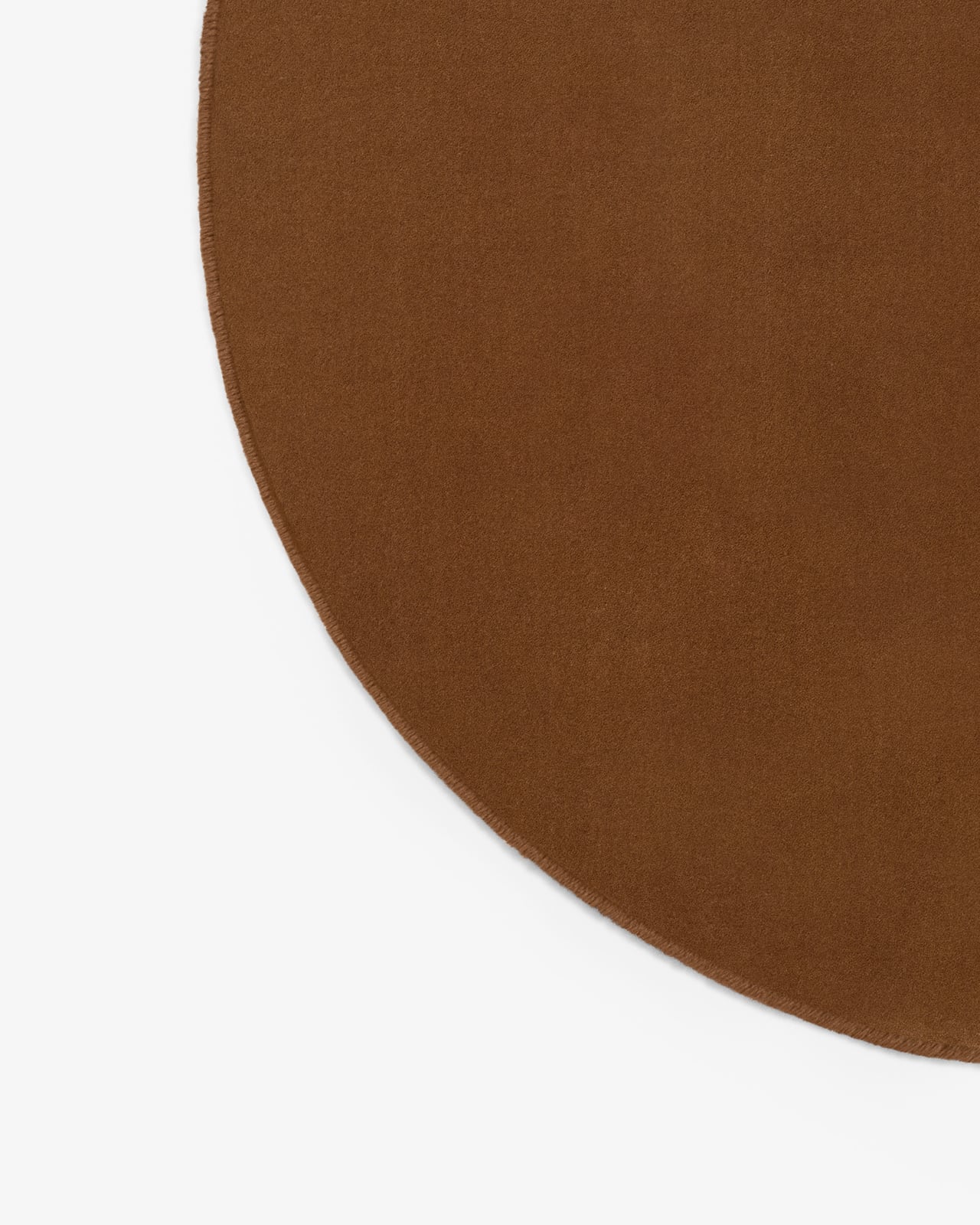 Close-up of Grand in Pecan, showing its smooth cut pile surface in a warm brown tone and hand-stitched edge binding.