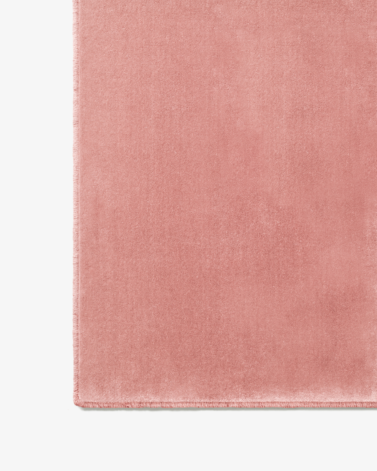 Close-up of the Grand - Sakura Pink - Custom Size rug, showing its plush texture and hand-stitched edge in a soft pink tone.