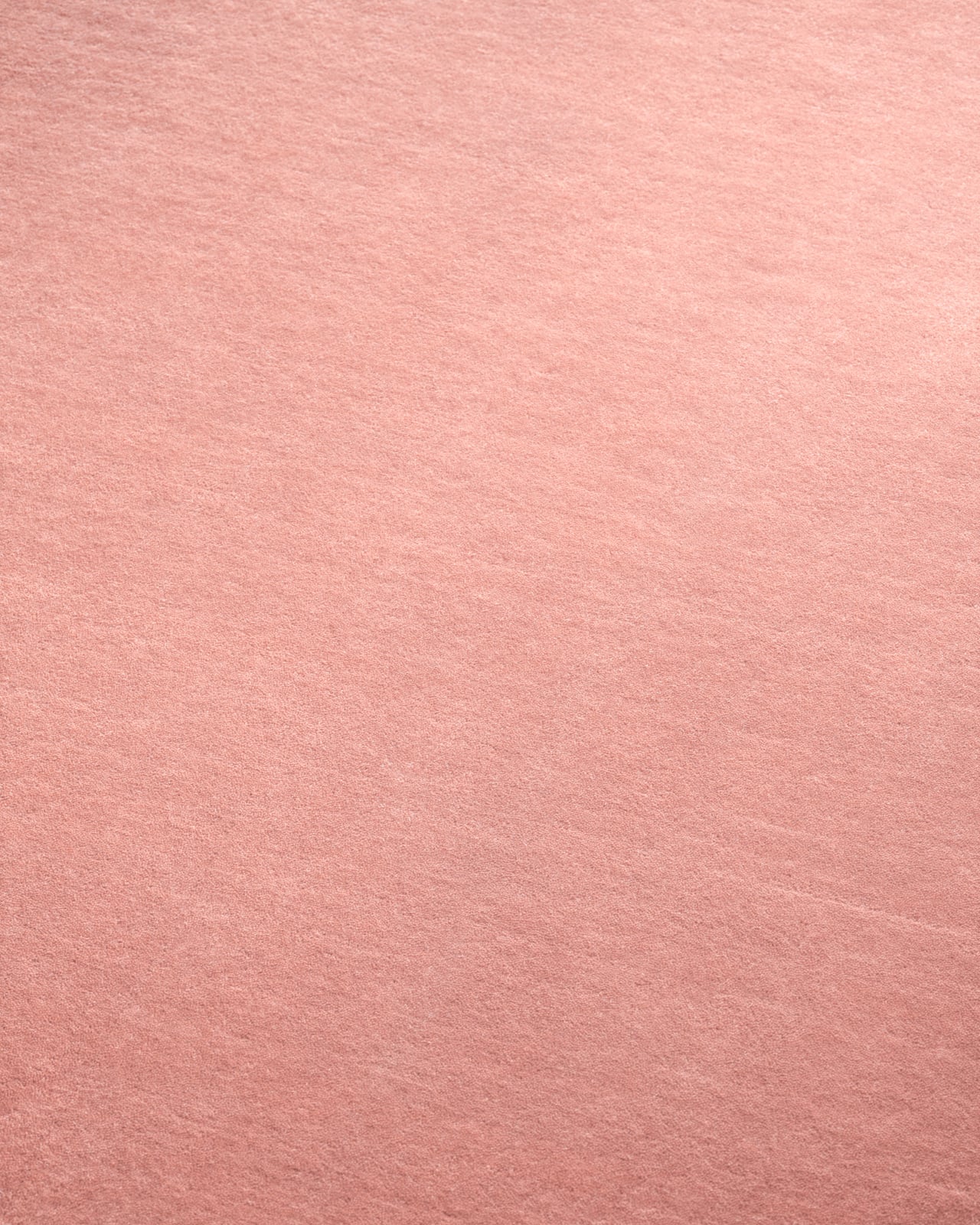 Close-up of Grand - Sakura Pink rug, showing its smooth cut pile in pink and serged edge.