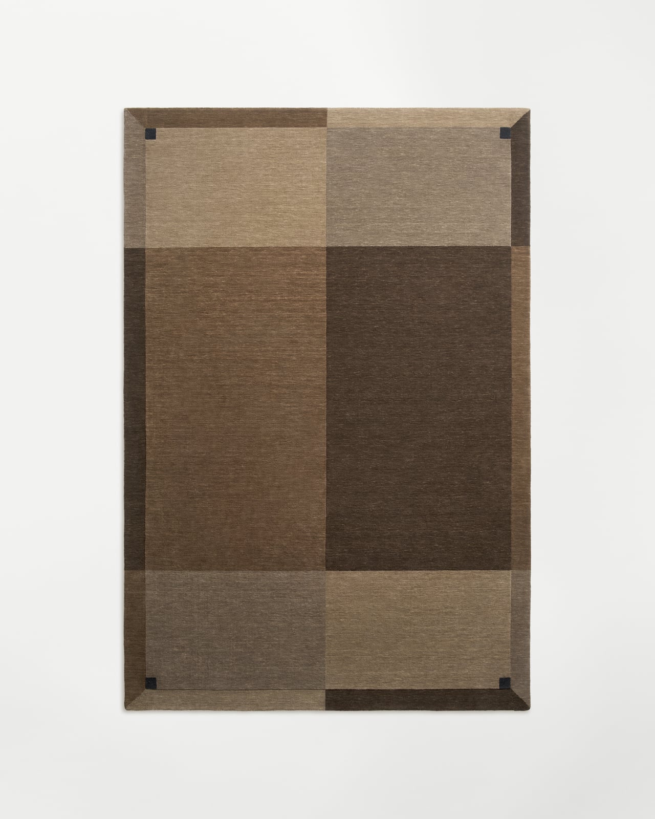 Parchment rug in Brown featuring a geometric color-block pattern with distinct rectangular panels and dark corner accents.