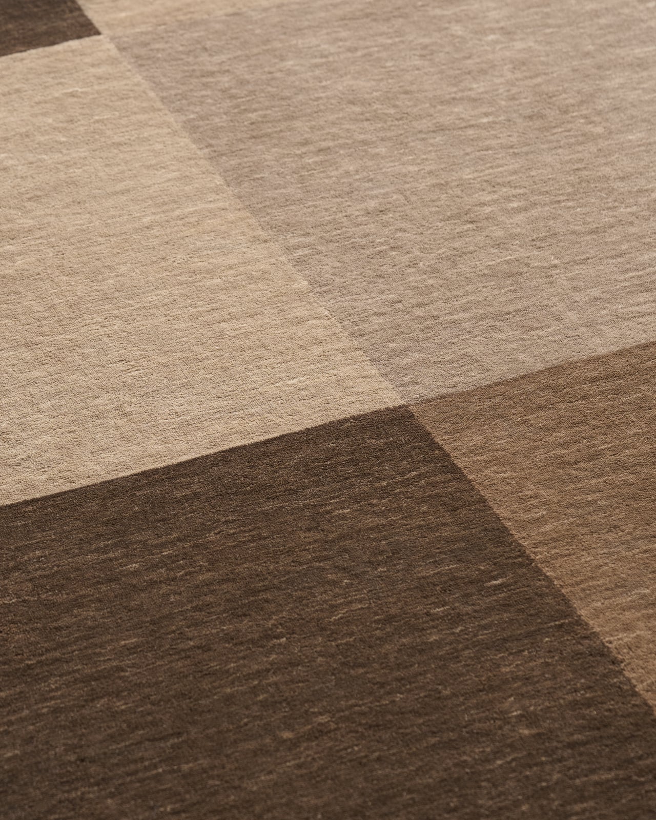 Parchment in Brown - a rug featuring geometric color-blocked rectangles in earthy brown tones with dark corner details.