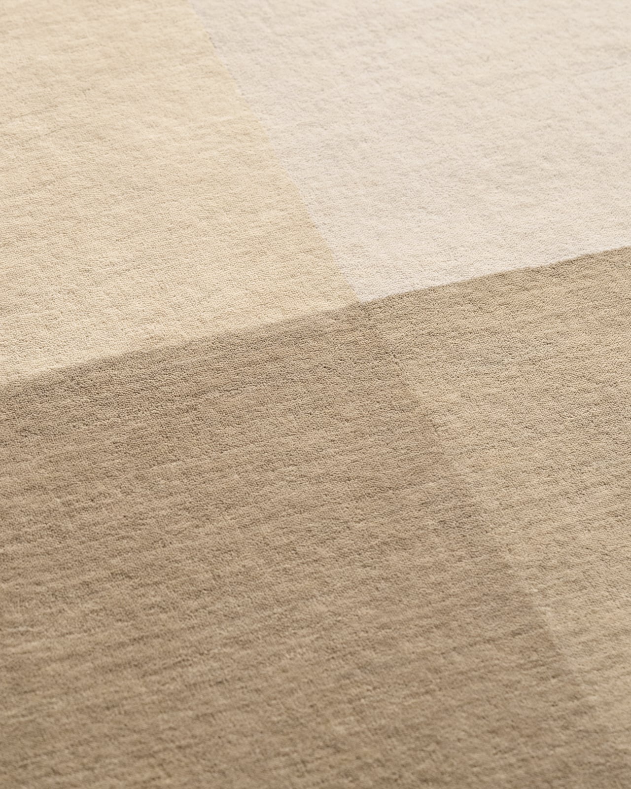 Parchment - Sand rug in beige tones featuring a geometric color-block pattern with dark corner accents and a border.