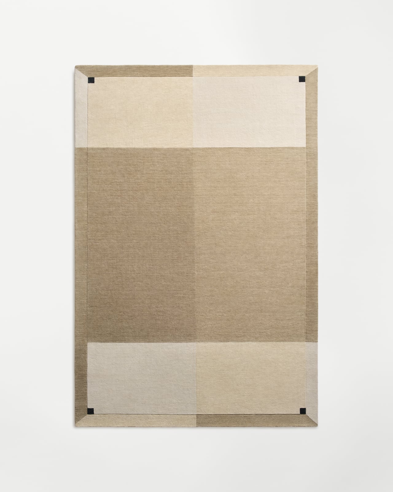 Parchment - Sand rug in beige tones featuring a geometric color-block pattern with dark corner accents and a border.