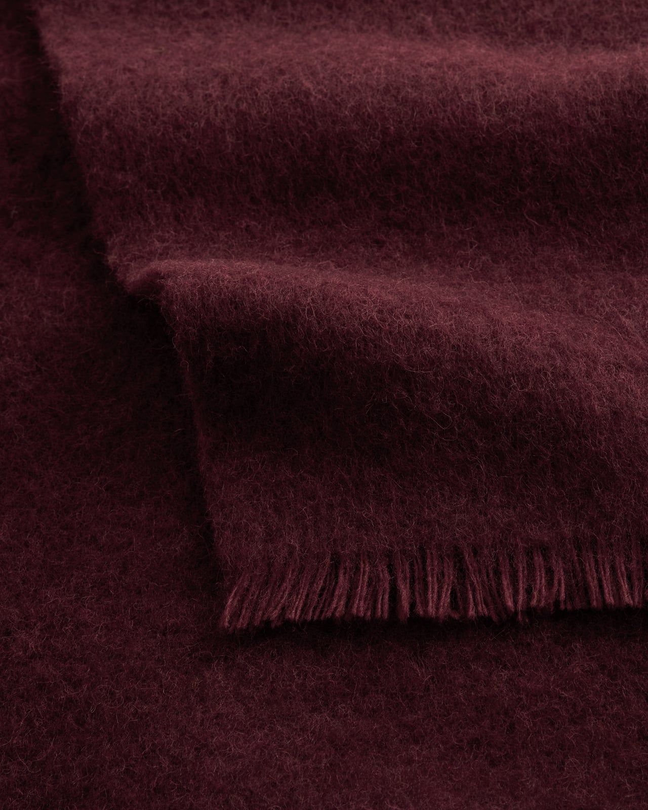 Solid Brushed Alpaca Throw in Deep Wine, a full-bodied red wool and alpaca throw with a brushed texture and delicate fringe.