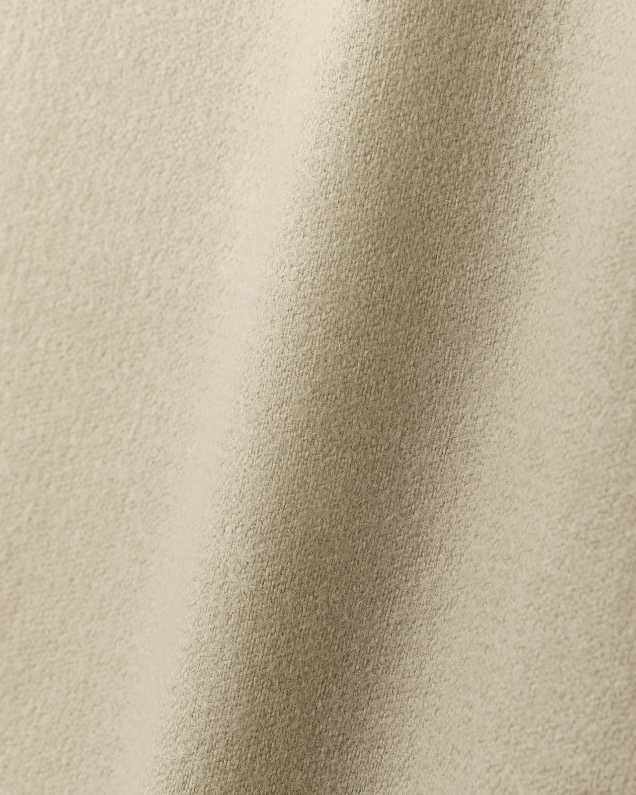 Close-up of Fabric by the yard - The Shelter in Sand, showing its dense wool twill weave and soft folds in a warm beige tone.