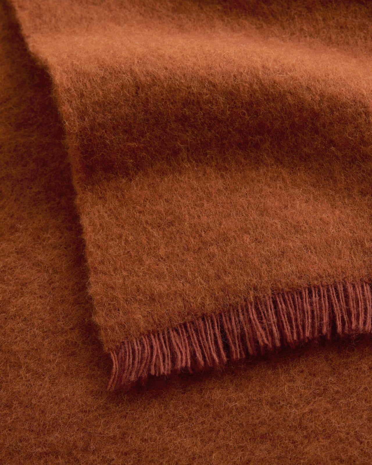 Solid Brushed Alpaca Throw in Burnt Orange, an earthy rust wool and alpaca throw with a brushed surface and delicate fringe.