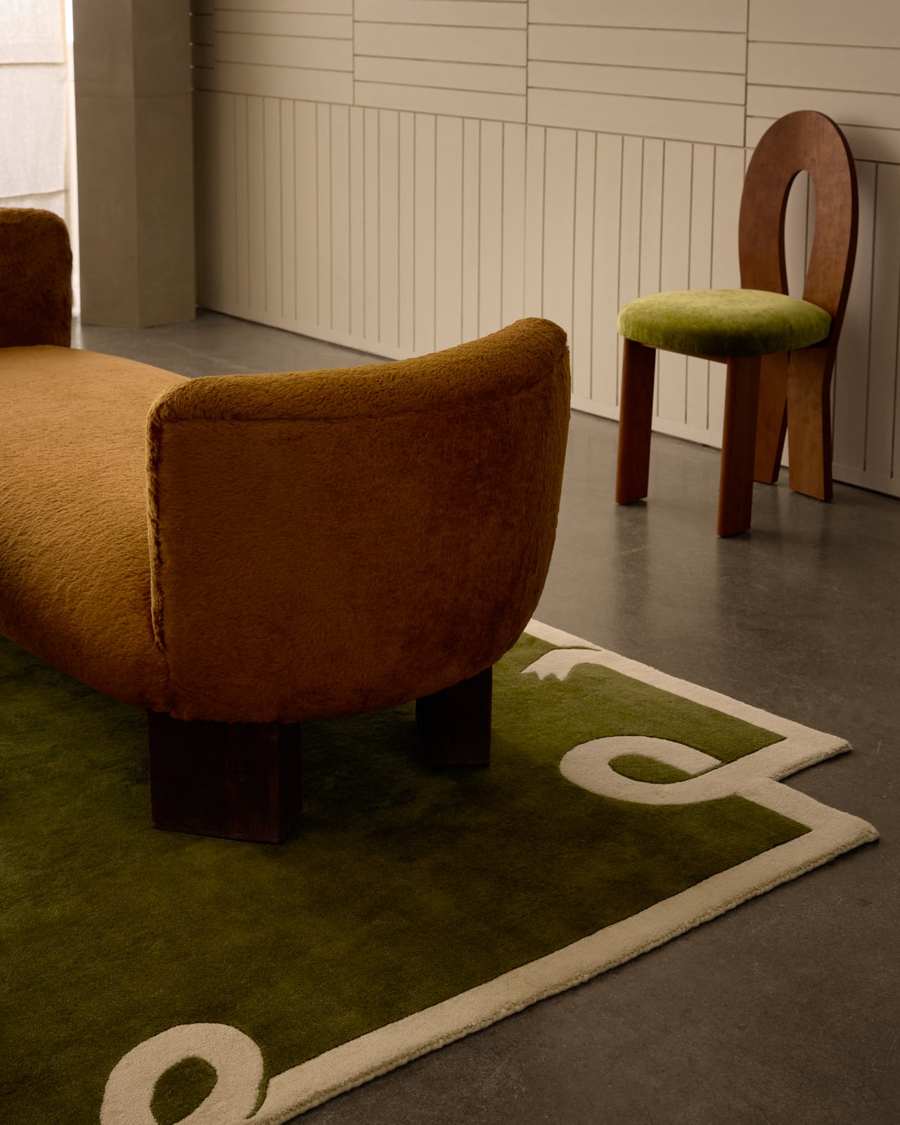 Loops - Green rug with a cream border and abstract loop details along the corners and edges.