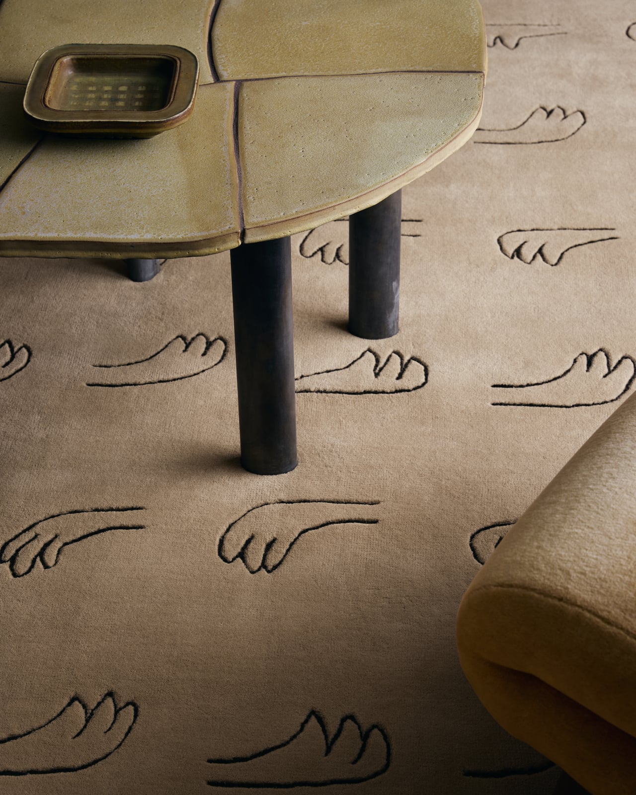 All Hands plush wool rug in Beige, featuring a repeated black hand-drawn motif and distinctive cut-out corners.